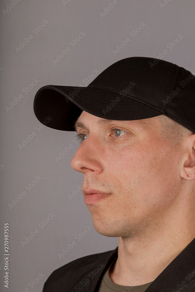 Handsome young man in a headdress on a gray background. Handsome young man in a headdress on a gray background.