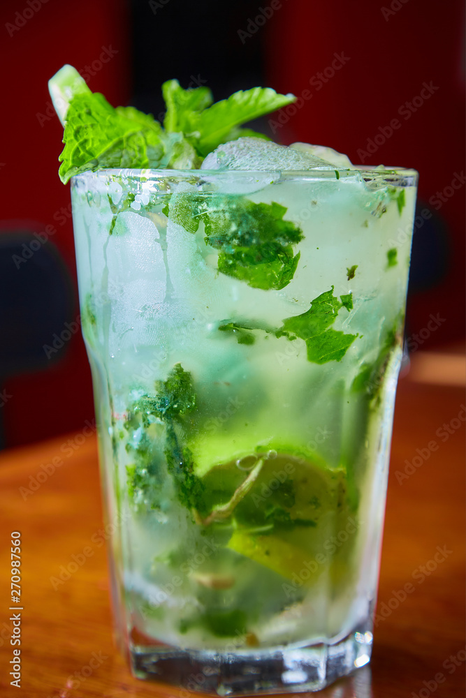 Summer fresh classic mojito with mint and lime garnish on bar top in restaurant Summer fresh classic mojito with mint and lime garnish on bar top in restaurant