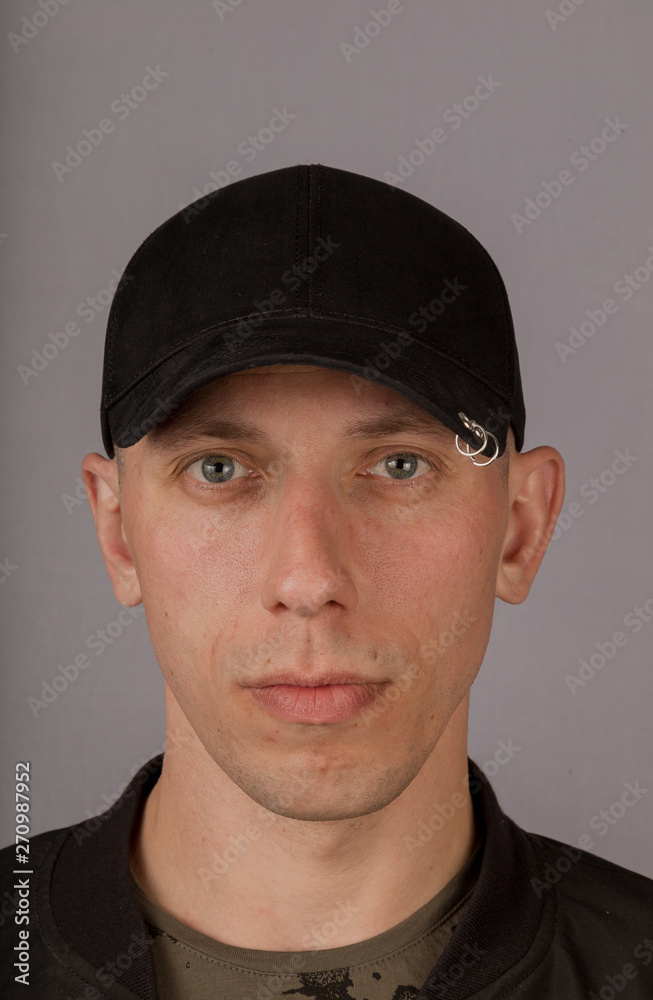 Handsome young man in a headdress on a gray background. Handsome young man in a headdress on a gray background.