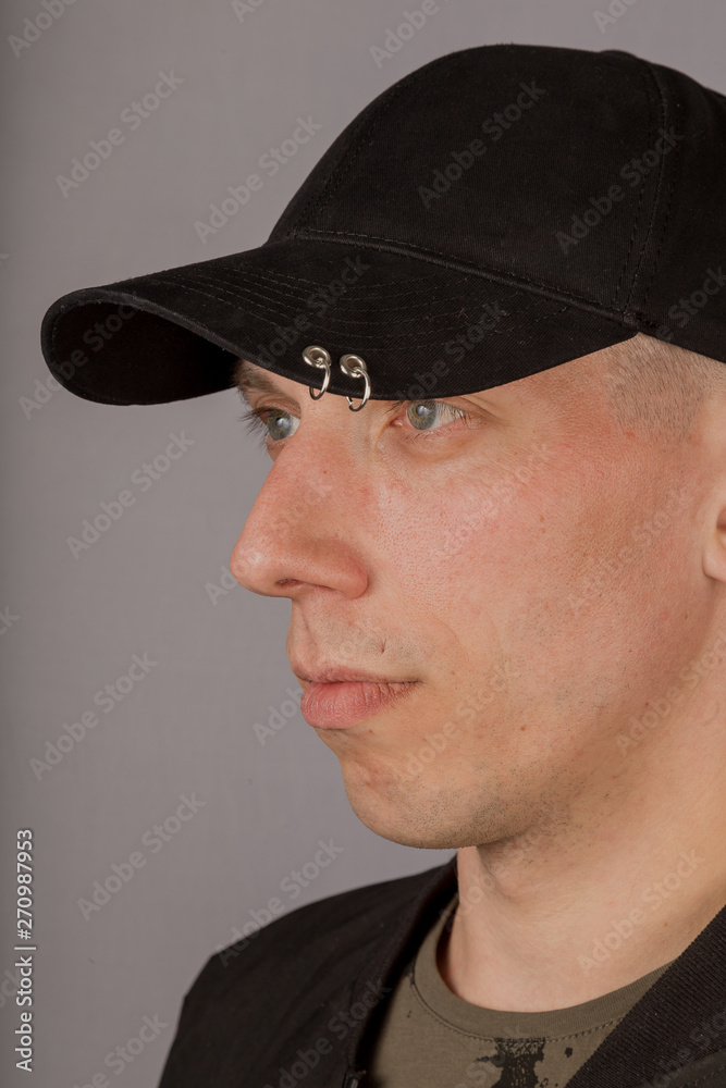 Handsome young man in a headdress on a gray background. Handsome young man in a headdress on a gray background.