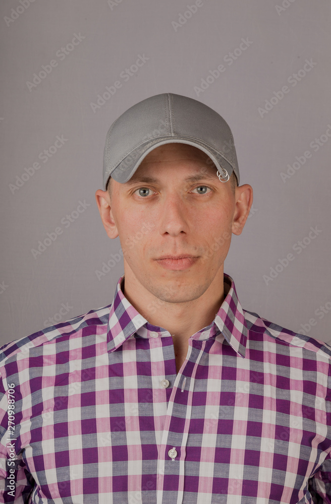 Handsome young man in a headdress on a gray background. Handsome young man in a headdress on a gray background.