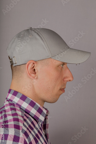 Handsome young man in a headdress on a gray background. © combo1982