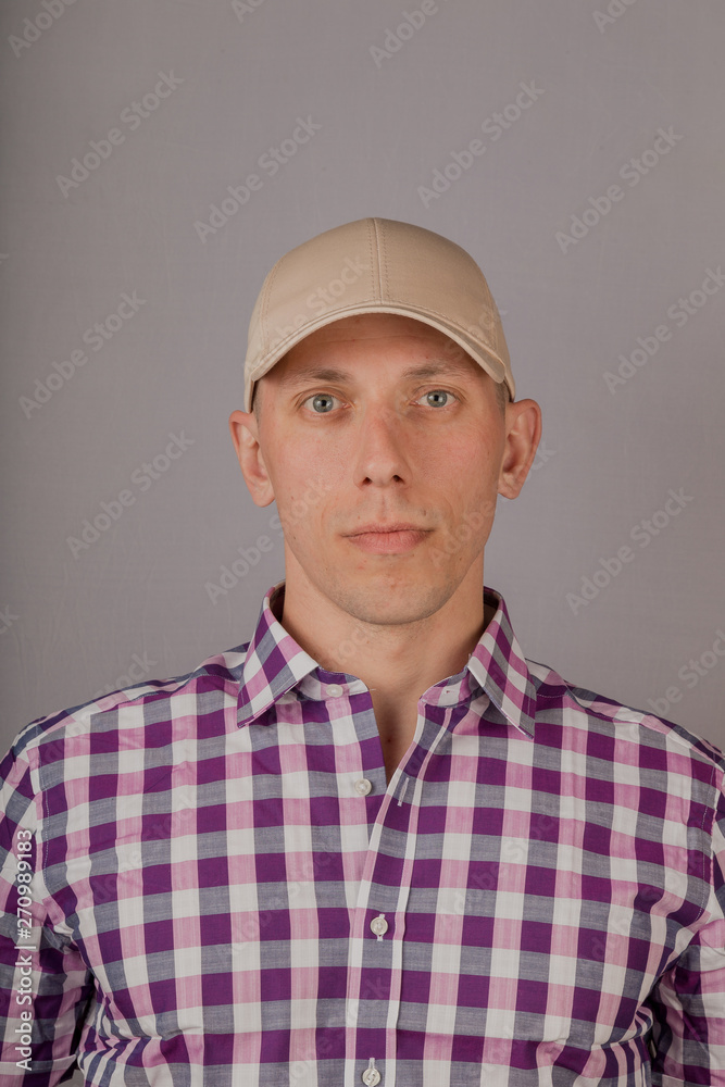 Handsome young man in a headdress on a gray background. Handsome young man in a headdress on a gray background.