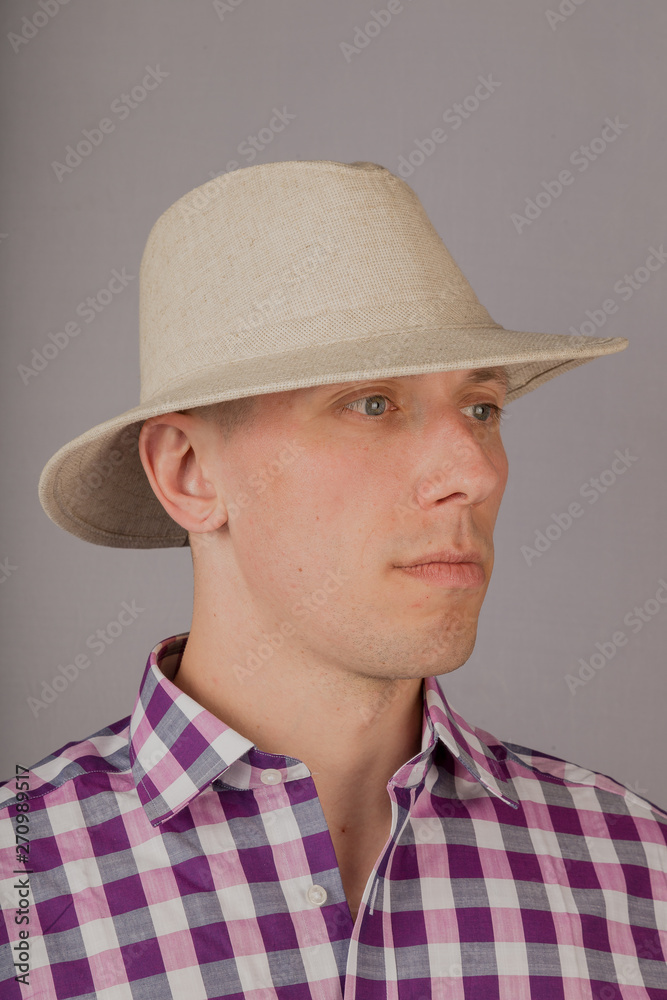 Handsome young man in a headdress on a gray background. Handsome young man in a headdress on a gray background.
