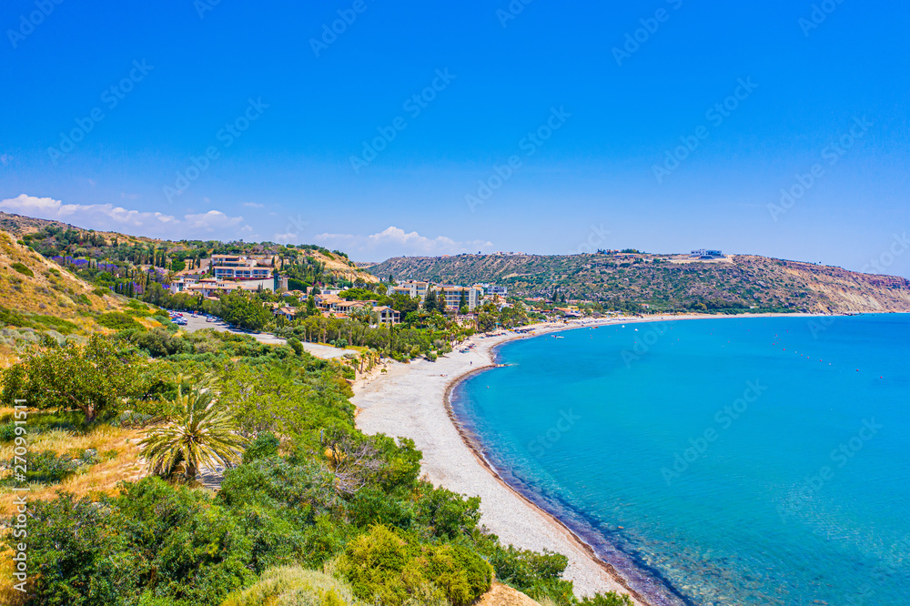 Pissouri. Cyprus. Pissouri bay beach high-rise panorama on a sunny day. The picturesque turquoise bay with a sandy beach. The Mediterranean sea coast. The Pissouri resort. Travel to Cyprus.