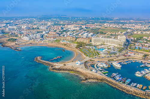 Cyprus. Protaras. The Paralimni harbour. Pernera. Kalamies beach high-rise panorama. Bay semicircular beach with sun loungers. St. Nicolas church Cyprus. Beach resort of Cyprus. Panorama with drone.