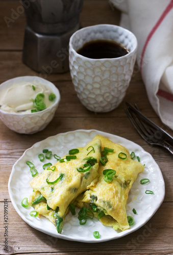 Homemade breakfast of omelet with asparagus and onions and hot coffee. Rustic style.
