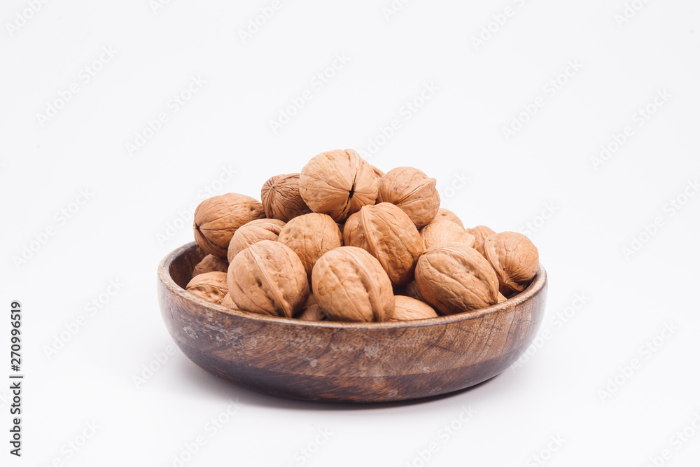 Wooden plate with walnuts isolated on white Wooden plate with walnuts isolated on white