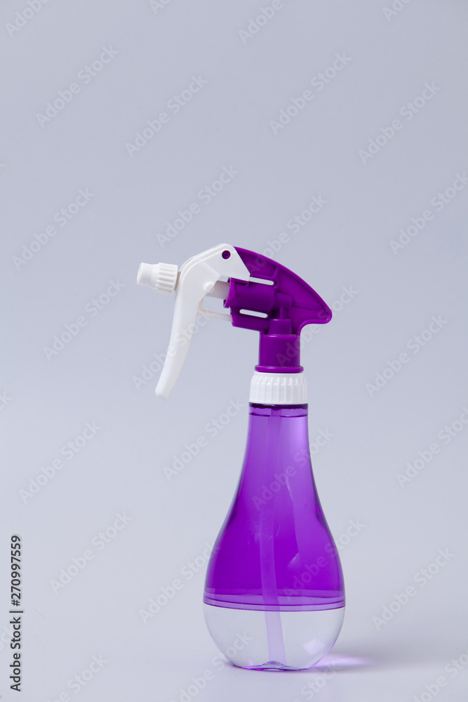 PurPle plastic bottle of spray on gray PurPle plastic bottle of spray on gray
