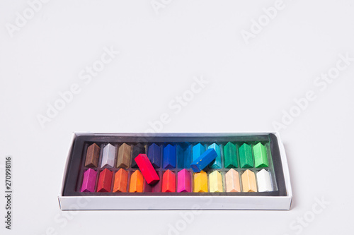 Chalk pastel stick on black container box on gray background 