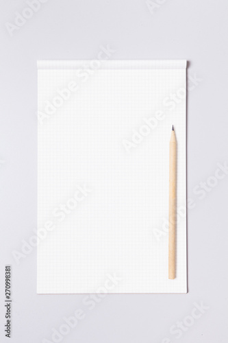 Grid note pad with pencil on gray background  © papii