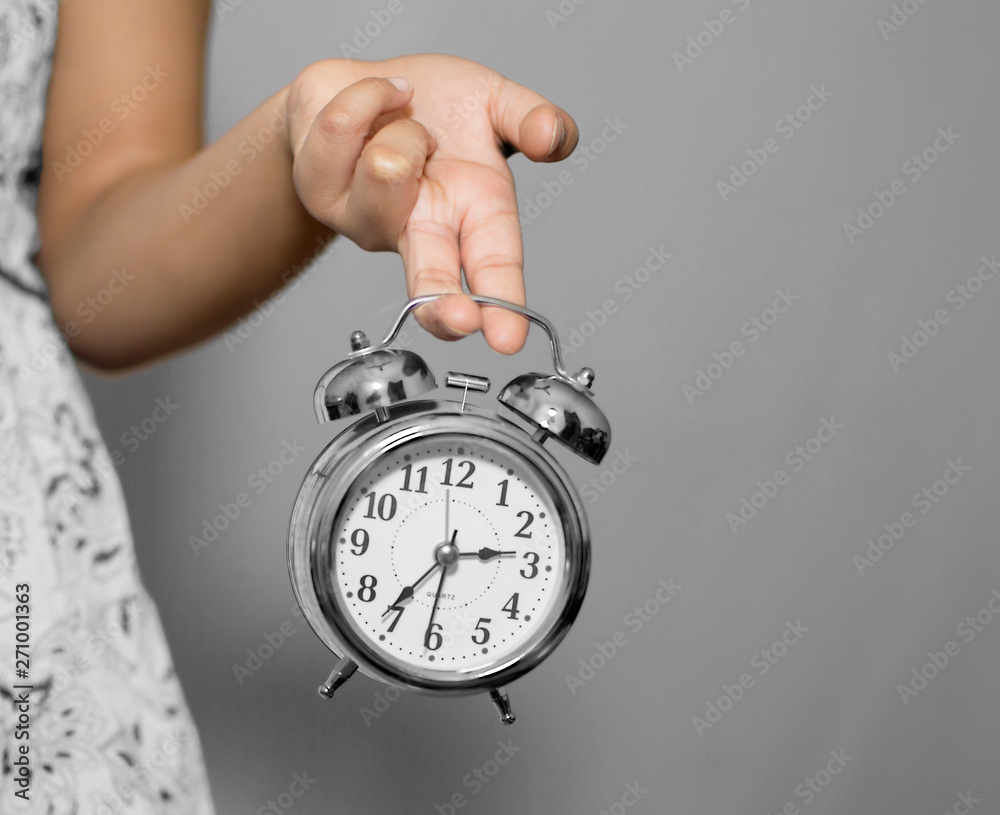 A girl holding alarm clock with fingers A girl holding alarm clock with fingers