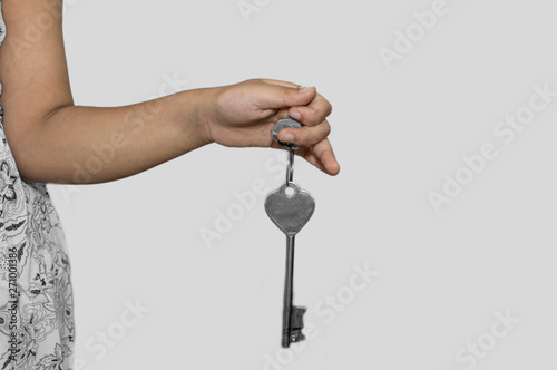 A women holds the key in her hand on white