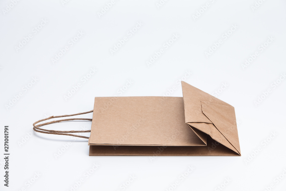 Brown kraft paper shopping bag lying on white Brown kraft paper shopping bag lying on white