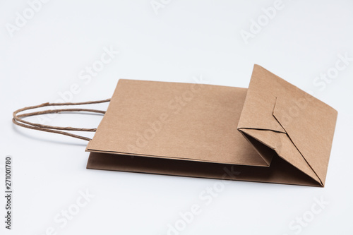 Brown kraft paper shopping bag lying on white 