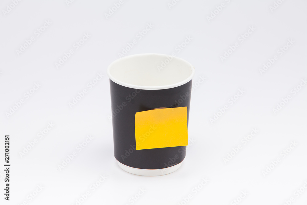 Black plastic paper coffee cup on white take away with yellow post note Black plastic paper coffee cup on white take away with yellow post note