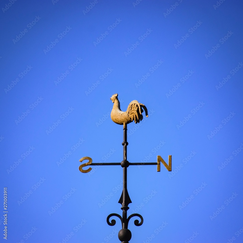 vane on roof with blue sky and clouds vane on roof with blue sky and clouds