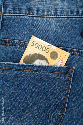 50000 won bill in the back pocket of blue jeans