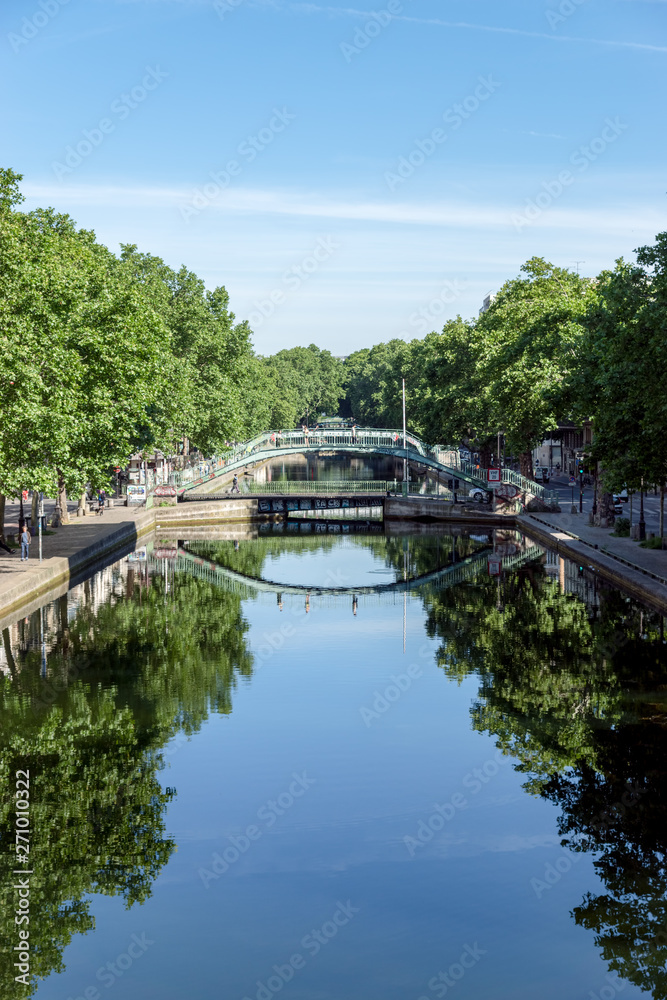 Paris, France: Pedestrian bridge over the Canal Saint-Martin with reflection in the water