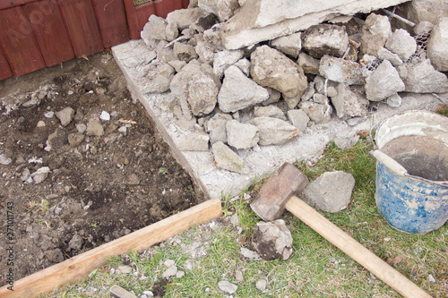 a huge sledgehammer breaks cement into stones