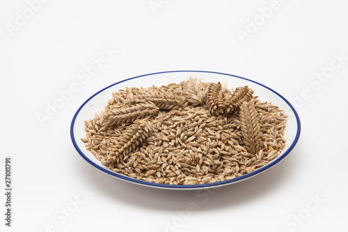 Ears of wheat and wheat grains in a plate