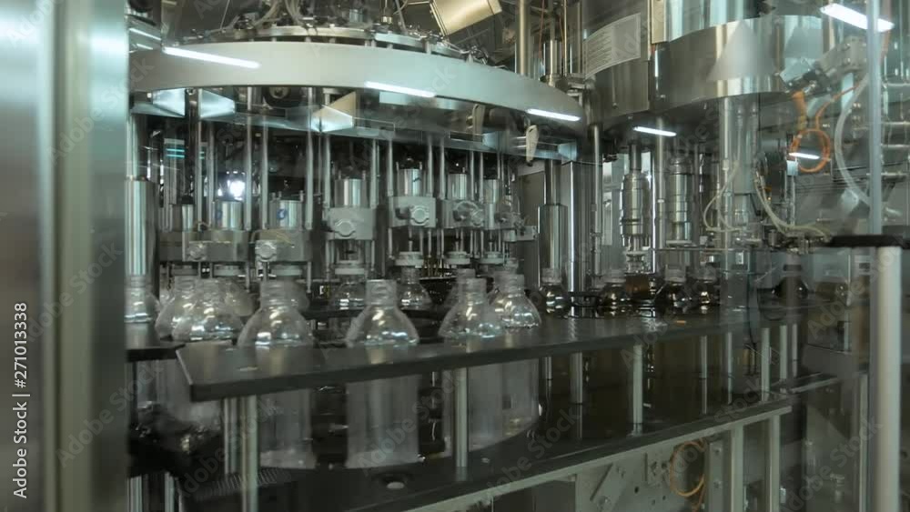 Plastic bottles inside industrial machine conveyor line or belt preparing for filling with drink. Water and juice bottling plant Plastic bottles inside industrial machine conveyor line or belt preparing for filling with drink. Water and juice bottling plant