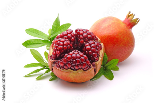 Pomegranate whole and cut with green leaves isolated on white background. Pomegranates (Punica granatum) is a fruit-bearing deciduous shrub in the family Lythraceae. Pomegranate fresh fruit Isolated. photo