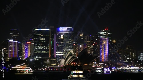 Wallpaper Mural Blurred boats floating on waters of Sydney harbour in view of city CBD waterfront during annual Vivid Sydney light show festival. Torontodigital.ca