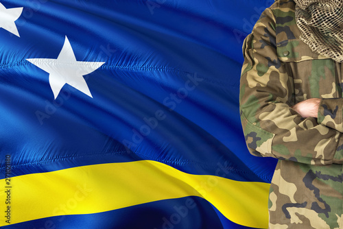 Crossed arms soldier with national waving flag on background - Curacao Military theme.