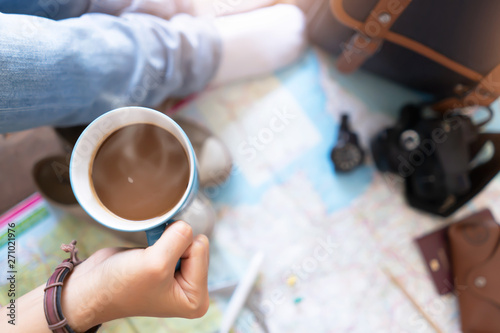 Hand hold coffee and planning for travel