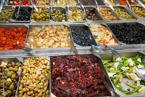 variety of colorful fresh vegetable salad in container in restaurant