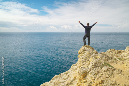 Man on sea cliff edge.