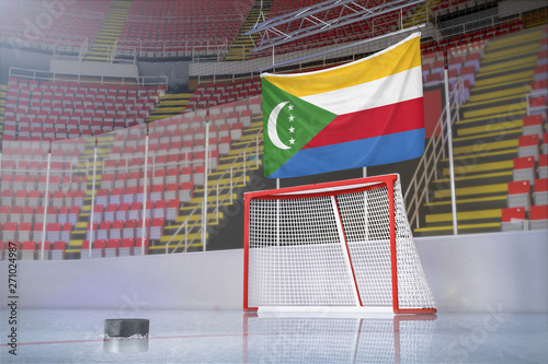 Flag of The Comoros in hockey arena with puck and net