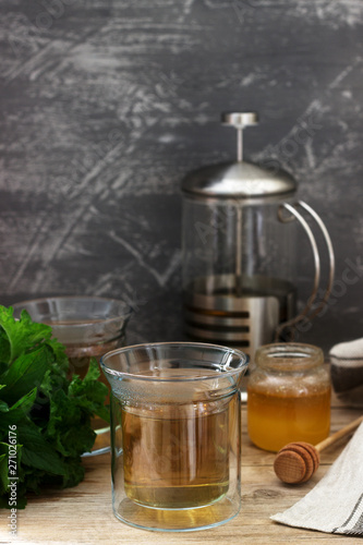 Herbal tea made from mint and lemon balm with honey in glass cups. Rustic style.