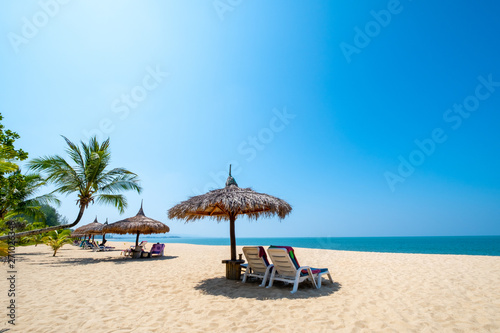 Beach chairs, umbrella and palms on sandy beach near sea. island in Phuket, Thailand. Travel inspirational, Summer holiday and vacation concept for tourism relaxing.