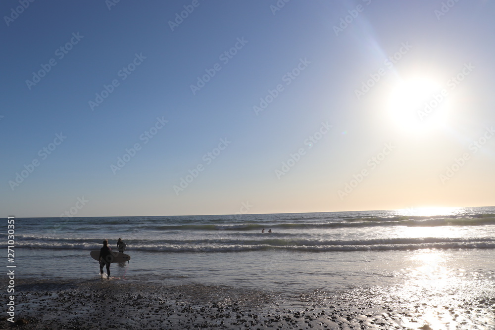 surfer walking on beach