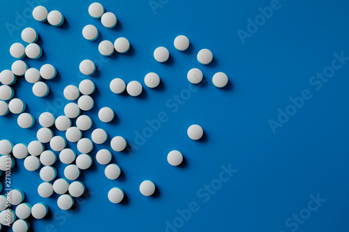 Assorted pharmaceutical medicine pills, tablets and capsules.Pills background. Heap of assorted various medicine tablets and pills different colors on blue background. Health care.Top view.Copy space