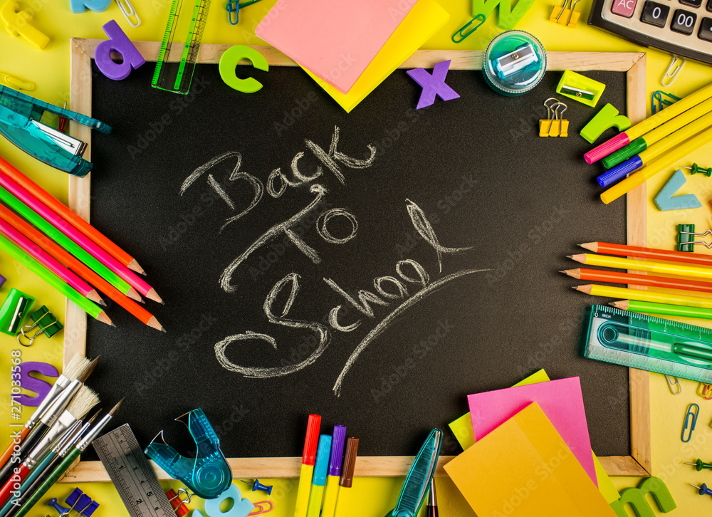 Back to School concept school and office supplies on a yellow background all stationery items with black board Back to School concept school and office supplies on a yellow background all stationery items with black board