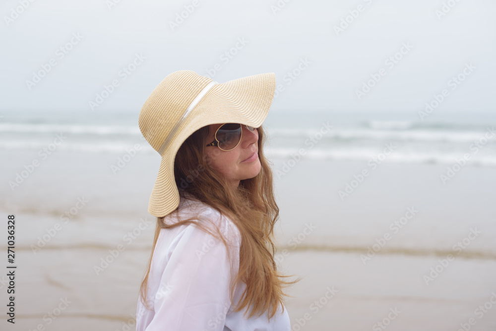 woman in a hat near the ocean