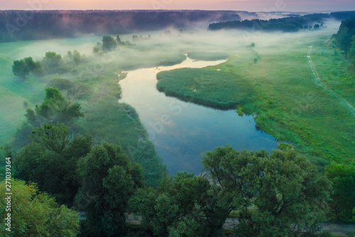 Early misty morning, sunrise over the lake. Rural landscape in summer. Aerial view