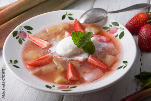 Rhubarb soup with strawberries and ice cream in