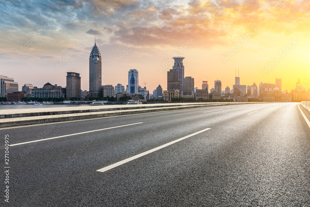 Shanghai bund city skyline and empty asphalt highway at sunset