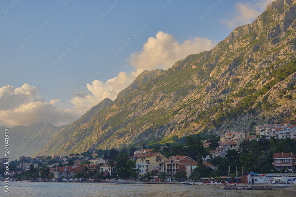 Boko Kotor bay at sunset, the clouds over the mountains, the sun at sunset leaving into the sunset.