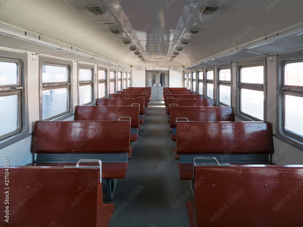 Empty train car with seats perspective.