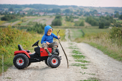 Child with a toy tractor on a trip.