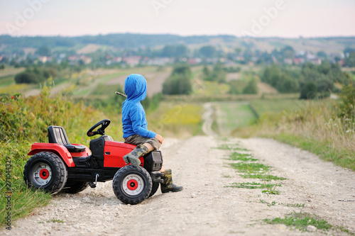 Child with a toy tractor on a trip.