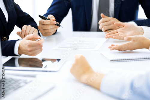 Fototapeta Naklejka Na Ścianę i Meble -  Group of business people and lawyers discussing contract papers sitting at the table, close-up. Successful teamwork, cooperation and agreement concepts