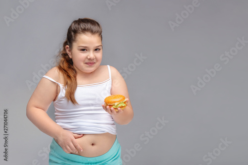 healthy eating, glutton, bad nutritional habits, overeating, fast food, overweight. baby girl with excess weight keeps the stomach. copyspace