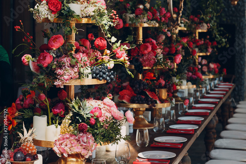 Fototapeta Naklejka Na Ścianę i Meble -  Wedding table flowers with fruits and berries decor in red white pink green colors.