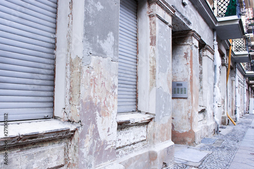 The image of old apartment exterior in downtown in east Berlin, Germany. The building exterior is faded and damaged because it is old.